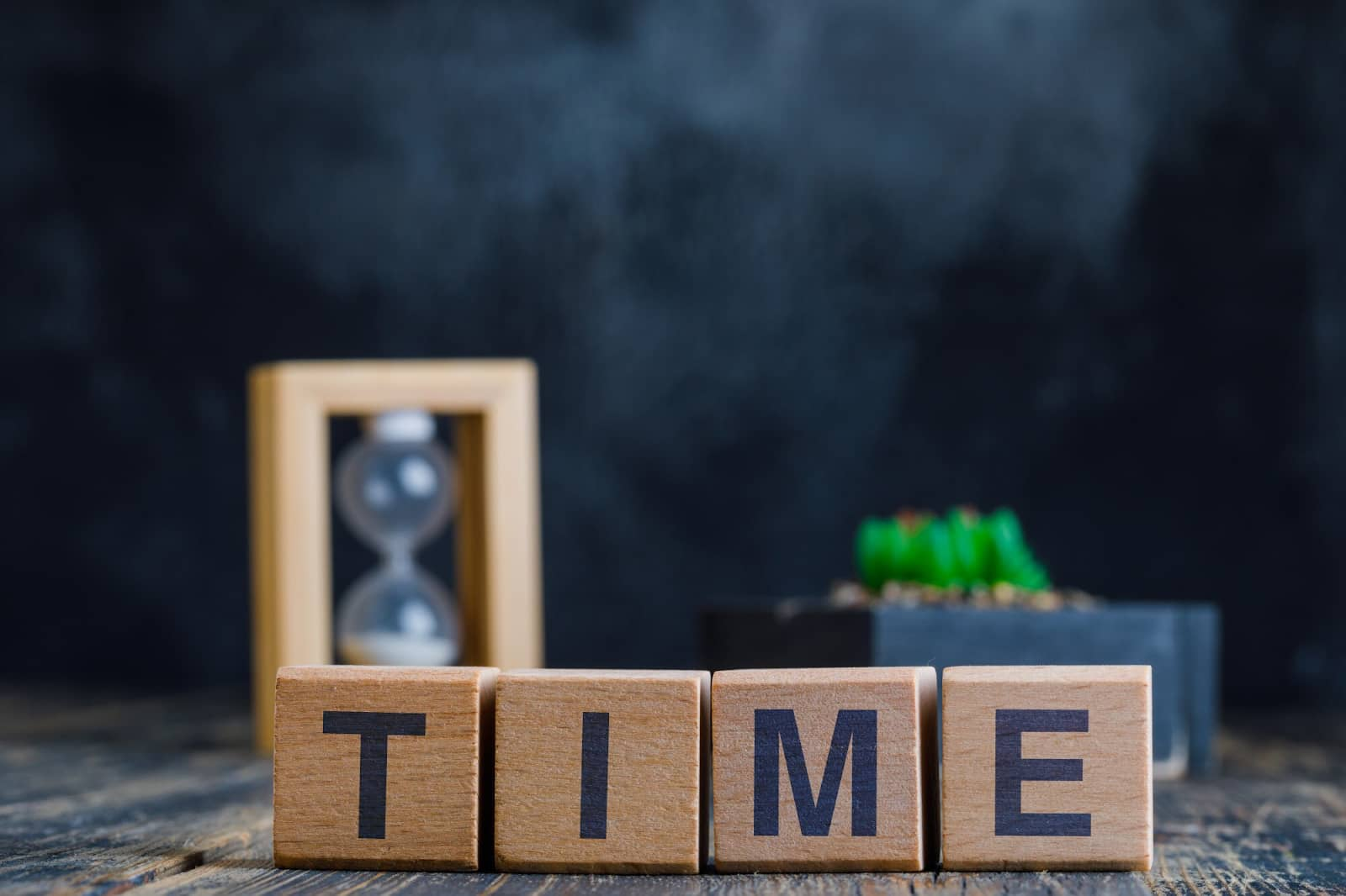 Word time on wooden cubes with hourglass background