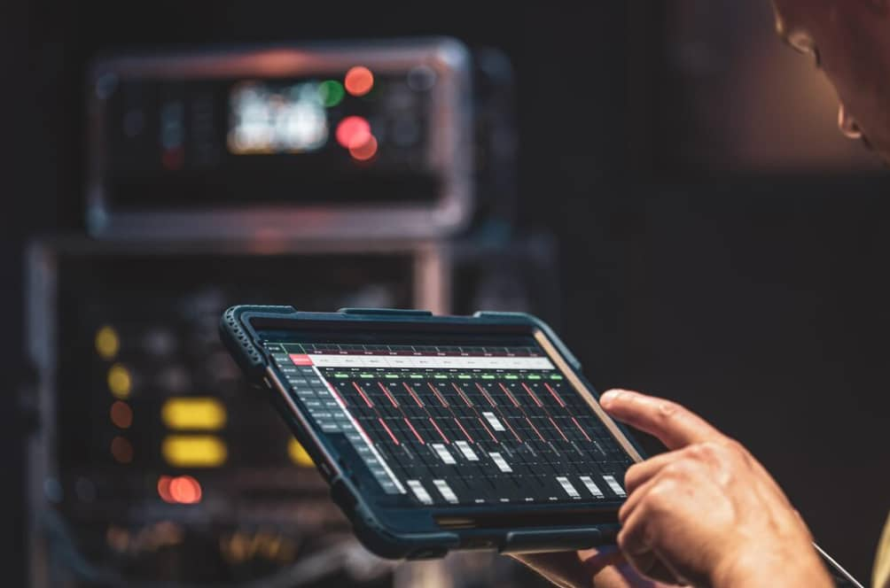 Close-up of hands adjusting settings on a digital mixing console app