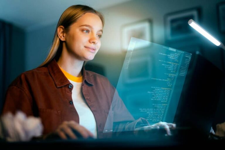 A woman smiling while coding on a transparent computer screen